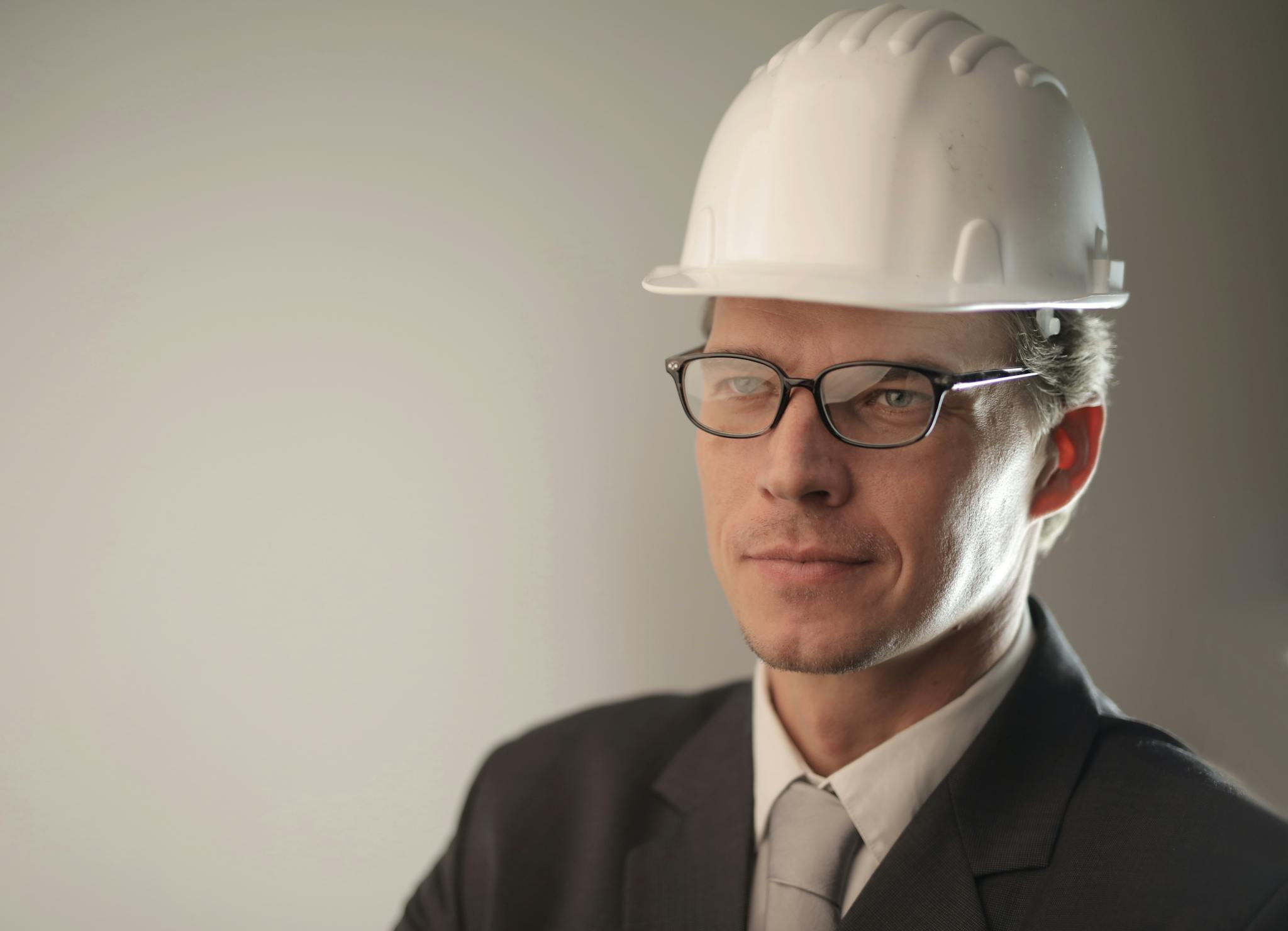 Confident engineer in suit and hard hat, ready for construction project.