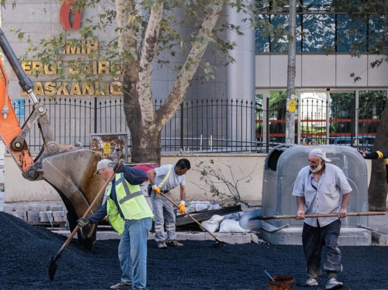 Workers conducting street maintenance on asphalt in İzmir, Türkiye.